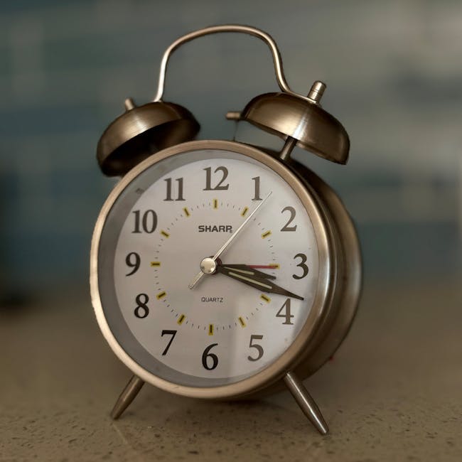Close-up of a classic metal alarm clock in a cozy indoor setting.